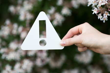 holding paper cut miniature exclamation mark over blooming treeの写真素材