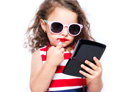 Adorable funny little girl making makeup with mother cosmeticsの写真素材