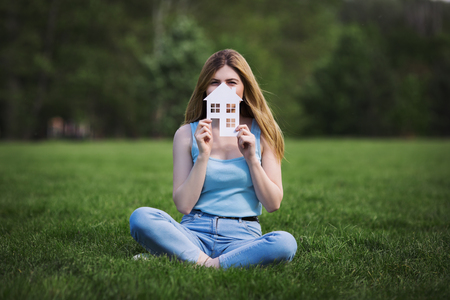 girl with cardboard figure of houseの写真素材