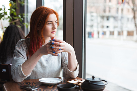 Young Attractive Woman Enjoying A Cup Of Coffee in Cafe.の写真素材