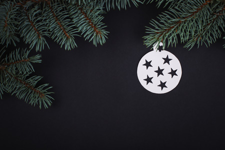 Merry Christmas card decorations in paper cutting style hanging on fir over black.の写真素材