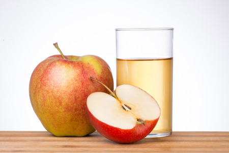 Apples with glass of juice on white background.の写真素材