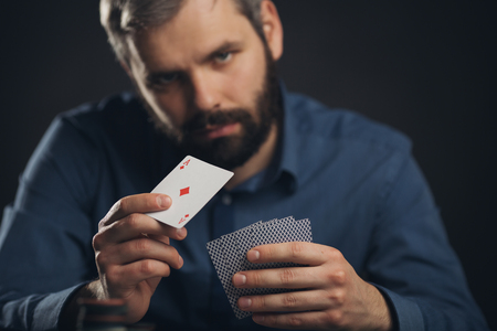 Men with poker cards on balck background.