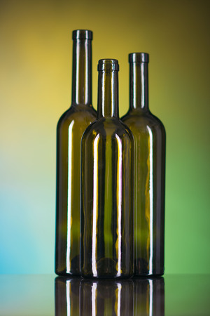 three brown bottles on a multi-colored backgroundの写真素材