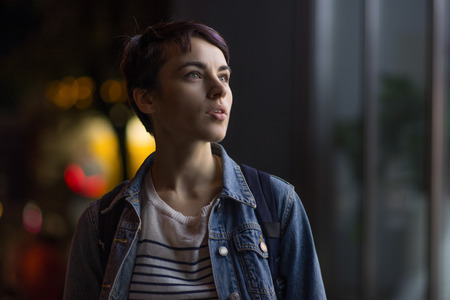 beautiful brunette with short haircut on a background of a night city