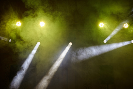 yellow light, smoke, floodlight on a dark backgroundの写真素材