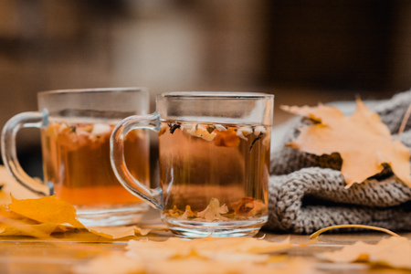 2 cups of tea, scarf and yellow leaves on a wooden tableの写真素材