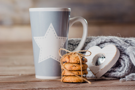 cup with tea scarf and biscuit on a wooden backgroundの写真素材