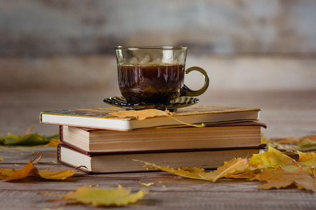 cup of coffee book and leaves on a wooden backgroundの写真素材