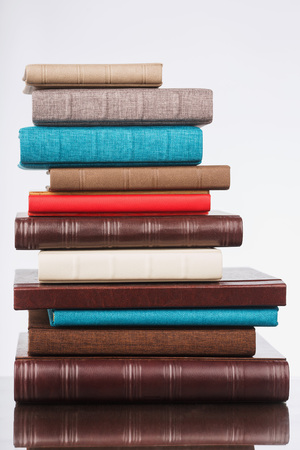 multi-colored albums of different sizes and textures on a white background