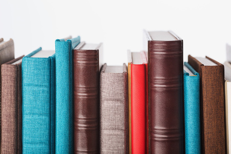 multi-colored albums of different sizes and textures on a white backgroundの写真素材