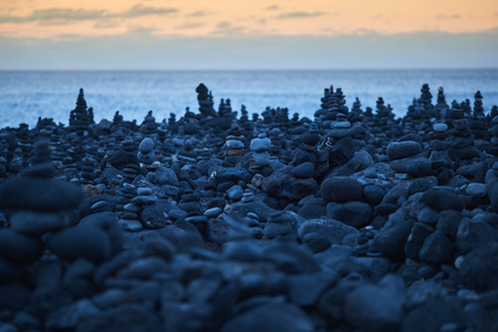 many round stones stacked on top of each other by the ocean