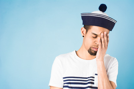 african american guy dressed in sailor uniform on blue backgroundの写真素材