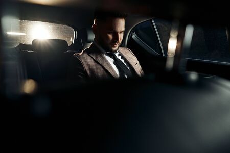 guy in car with laptop and phoneの写真素材