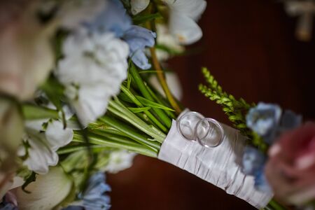 wedding rings for newlyweds in white gold on flowersの写真素材
