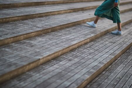 girl in white sneakers and pants walking on the stairsの写真素材