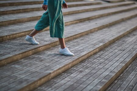 girl in white sneakers and pants walking on the stairsの写真素材