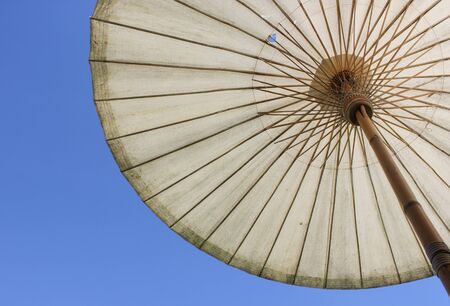 Big bamboo umbrella for outdoors with sky background. Umbrella handmade in the north of Thailand.の写真素材