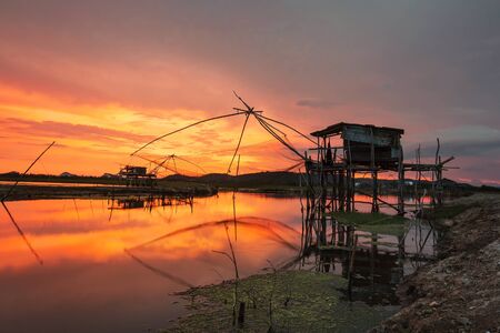 Silhouette abandoned house on lake with fishing netの写真素材