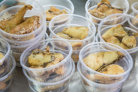 Preparing fried fish in plastic food package for take awayの写真素材