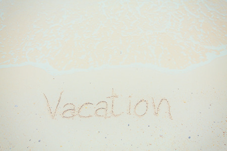 Handwritten Word Vacation On Sand Of Beach with vintage style,background and textureの写真素材