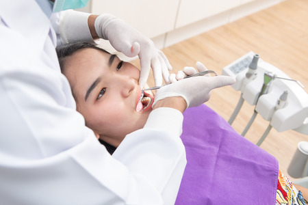Dentist checking patient woman teethの写真素材
