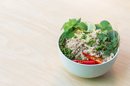 Top view after hot water bowl of instant noodles and Spices, vegetables on woodenの写真素材