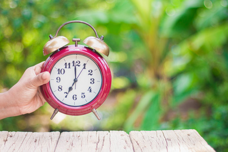 Use the red alarm clock handles to see the time in the morning.With a green background, orange, warmの写真素材