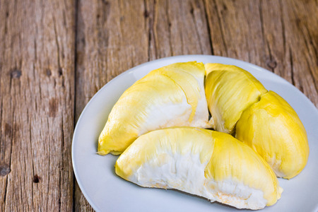 Close-up shots of durian in a white container. Put on a wooden floor for eating.の写真素材