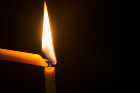 Candlelight with a candle in the night on a black background.の写真素材