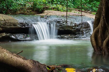 Waterfalls flowing from the forest in morningの写真素材
