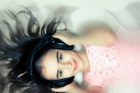 Young girl listening music in phonesの写真素材
