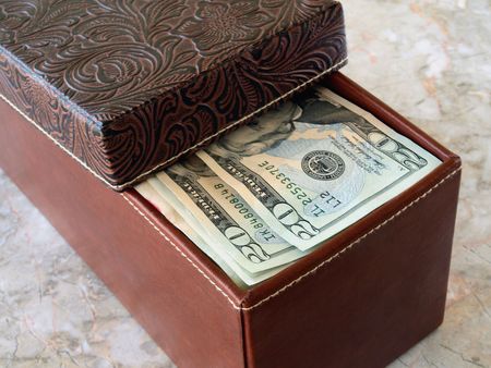 brown leather box with us dollars on the tableの写真素材