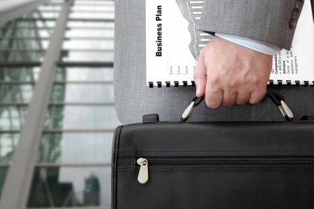 Businessman with Business Plan and Briefcase Ready for Meeting   の写真素材
