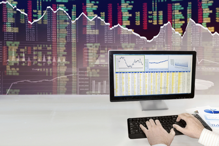 Man analyzing financial data and charts on computerの写真素材