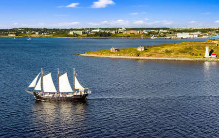 HALIFAX, NOVA SCOTIA, CANADA - SEPTEMBER 13, 2019: Panoramic view of Halifax Harbor with lighthouse and touristic sail ship in  on sunny dayのeditorial素材