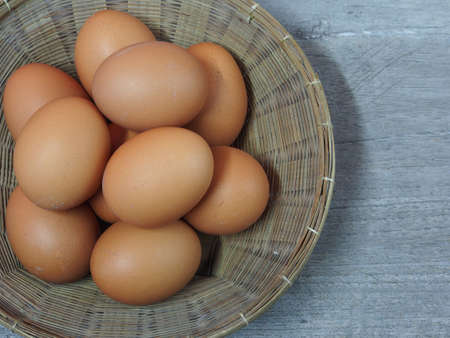 Fresh eggs in basket on wooden background
