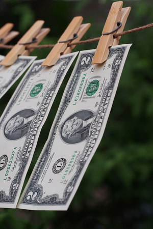 Two dollar bill fixed on clothes peg with green blur backgroungの写真素材