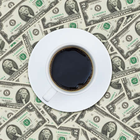 A cup of coffee on money dollar bill pattern backgroundの写真素材
