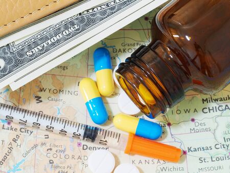 Medicine pills and money on map for travelの写真素材