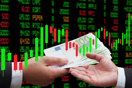 Investor giving euro money to his business partner, under Candlestick Chart, investment conceptの写真素材
