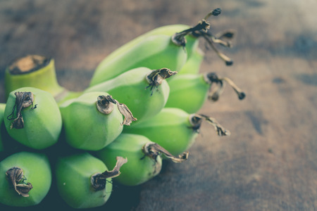 Green banana on wooden tableの写真素材