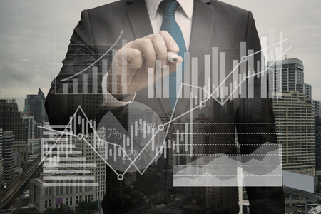 Double exposure of Businessman writing the virtual panel of pie chart and other chart , business conceptのeditorial素材