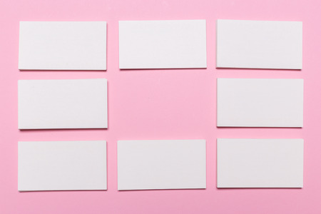 Blank white business cards on pink background. Mockup for branding identity. Template for graphic designers portfolios. Top view.の写真素材