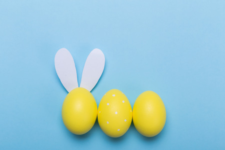 yellow easter eggs in nest on pastel color background with space.の写真素材