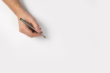 Close-up hand writing with a pencil, brown wooden pencil in hand, isolated on white background with clipping pathの写真素材