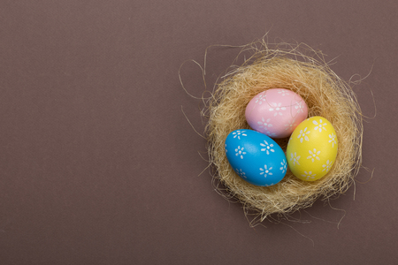 Colorfull easter eggs in nest on pastel color background with space. Conceptの写真素材