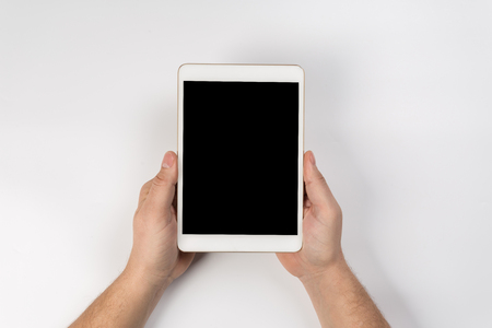 Hand touch on empty screen of tablet above brown table top view, Leave space for display of your content, Technology concept, mock up for montage your contentの写真素材