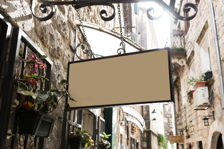 shape traditional bar signage mockup in old city center. blank mockup outdoor advertising with copy spaceの写真素材