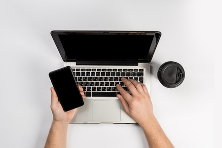 Male hands working on modern laptop. Office desktop on white backgroundの写真素材